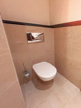 Zarif fayanslı bir banyoda yüzen tuvalet.