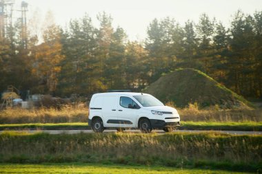 Çimen tarlasından geçen bir teslimat aracı.