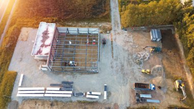 İnşaat alanının havadan görüntüsü, ağır makinelerin gün batımında yeni bir ticari gelişim sağladığını gösteriyor.