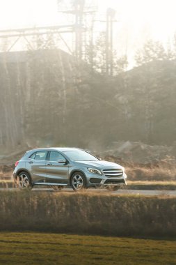 Huzurlu kırsal yolda ilerleyen kompakt araba