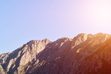 Alçak bulutlar kayalık yeşil dağ yamaçlarını kaplıyor