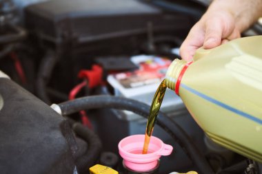 Tamirci araba motoruna sentetik yağ ekliyor