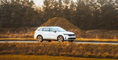 Gün batımında kırsal yolda bir cip hareket halinde.