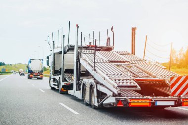 Yolda boş karavanı olan bir otomobil taşıyıcısı.