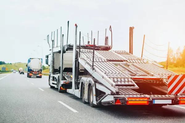 Yolda boş karavanı olan bir otomobil taşıyıcısı.