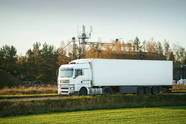 Lojistik kargo kamyonu açık yolda ilerliyor.