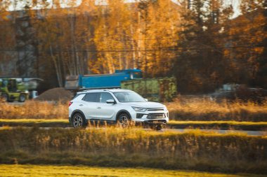 Beyaz şehir arabası inşaat alanının yakınında seyahat ediyor.