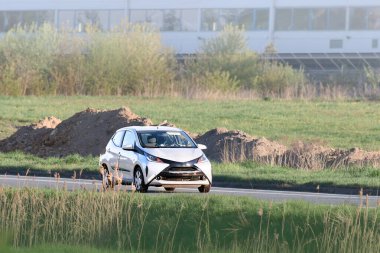 Şehir caddesinde hızlı giden kompakt araba.