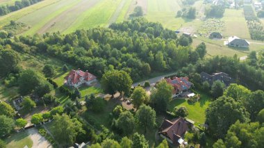 Drone 'un çektiği görüntüler ormanla çevrili bahçeli lüks bir evi gösteriyor. Doğa ve mimari arasındaki zıtlığı gösteriyor.