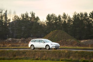 Açık kırsal yolda giden melez bir araç.