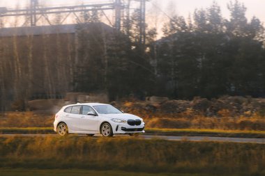 Kırsal bir yolda giden küçük bir hatchback arabası