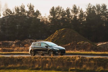 Güneşli öğleden sonra yolda küçük bir araba.