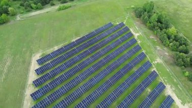 Güneş ışığını yakalıyor, güneş panelleri canlı yeşil bir alana yayılıyor.
