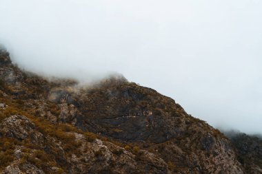 Kayalık dağ zirveleri açık mavi gökyüzüne uzanıyor