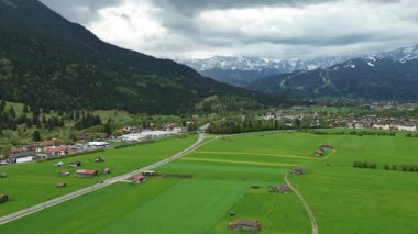 Bulutlu gökyüzünün altındaki renkli alp köyü