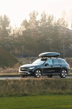 Çatıdaki bagaj kutulu nakliye aracı hareket halinde.