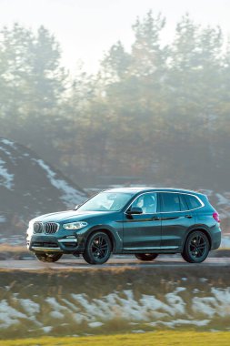 Orman manzarası yakınındaki yolda bir arazi aracı.