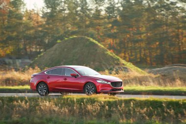 Sedan hibrid yeşilliklerle kırsal alanda ilerliyor.