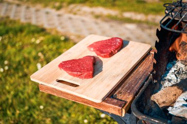 Şef ızgarada biftek pişiriyor.