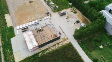 İnşaat alanının havadan görüntüsü, ağır makinelerin gün batımında yeni bir ticari gelişim sağladığını gösteriyor.