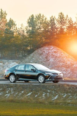 Şehir sokaklarında dolaşan siyah lüks bir sedan.