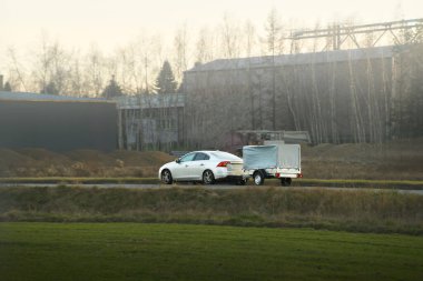 Aile arabası ve römork kırsal alandan geçiyor.