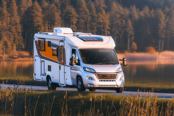 Туристический кемпер на сельской дороге возле гор