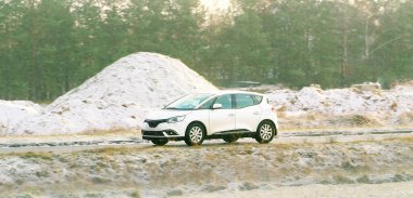 Soğuk karlı doğa sahnesinde araba sürüyor.