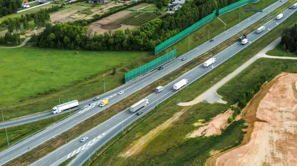 Yaz karayolunda beyaz kargo kamyonu sürüyor.