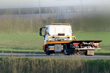 Gün batımında yol kenarında boş bir kurtarma kamyonu.