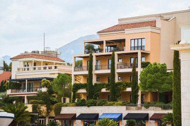 Balkonlarda yeşil bitkiler olan bir apartman kompleksi.