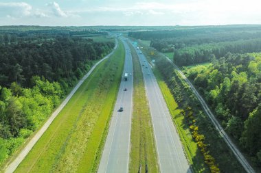 Bahar manzarasında turuncu ağaçlar otoyolda.