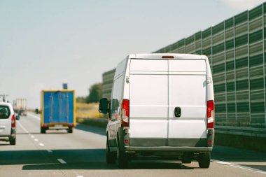 Beyaz minibüs açık yolda.