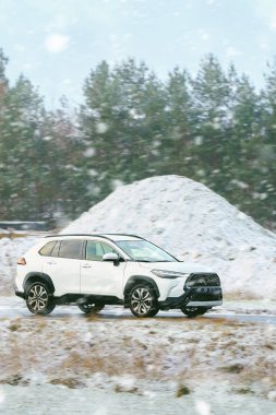 Araba karla kaplı yolda ilerliyor.