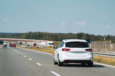 Otobanda beyaz araba sürüyor.