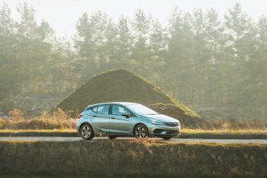 Güneşli öğleden sonra yolda küçük bir araba.