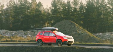 Küçük kırmızı SUV asfalt yolda ilerliyor