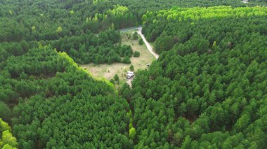 Yeşil ormanda güneş panelleri olan bir minibüs.