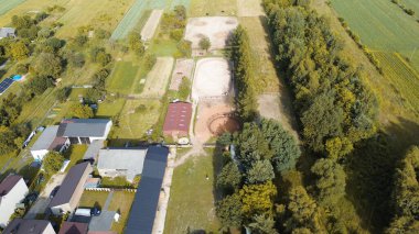 Binicilik sahaları ve ahırları olan binicilik tesislerinin hava görüntüleri.