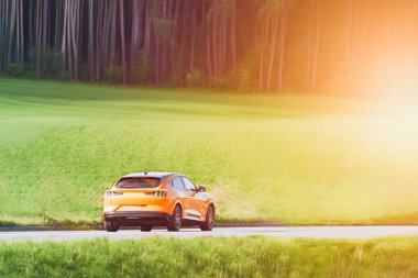 Kırsal kesimden geçen sarı elektrikli cip.