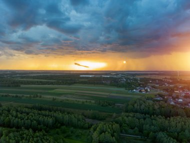 Kara fırtına bulutlarının yaklaştığı kırsal bölgede gün batımı