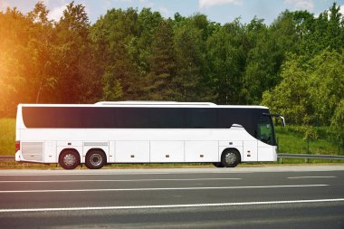 Boş yola park edilmiş beyaz tur otobüsü.