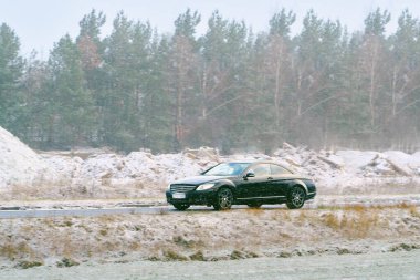 Lüks otomobil kış havasında yol alıyor.