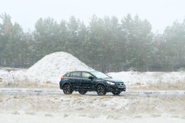 Karlı havada araba kullanan kompakt SUV