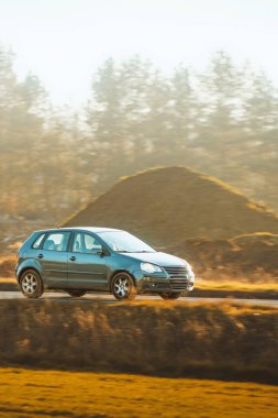 Kırsal yolda küçük bir hatchback sürücüsü