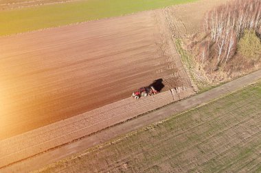 Traktör, sabanla sürülmüş toprakta izler bırakıyor.