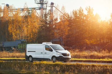 Beyaz minibüs çimen tarlasından geçiyor