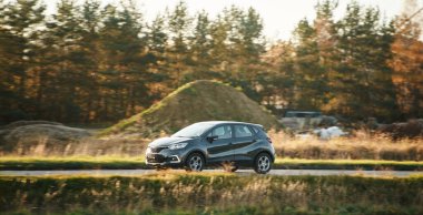 Güneşli kırsal yolda küçük bir araç.