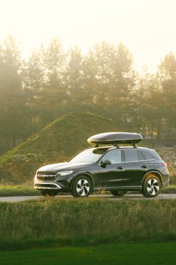 Otoyolda çatıya monte edilmiş kargo taşıyıcısı olan bir seyahat arabası.