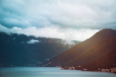 Yeşil dağlar ve gökyüzü tarafından çerçevelenmiş Idyllic gölü